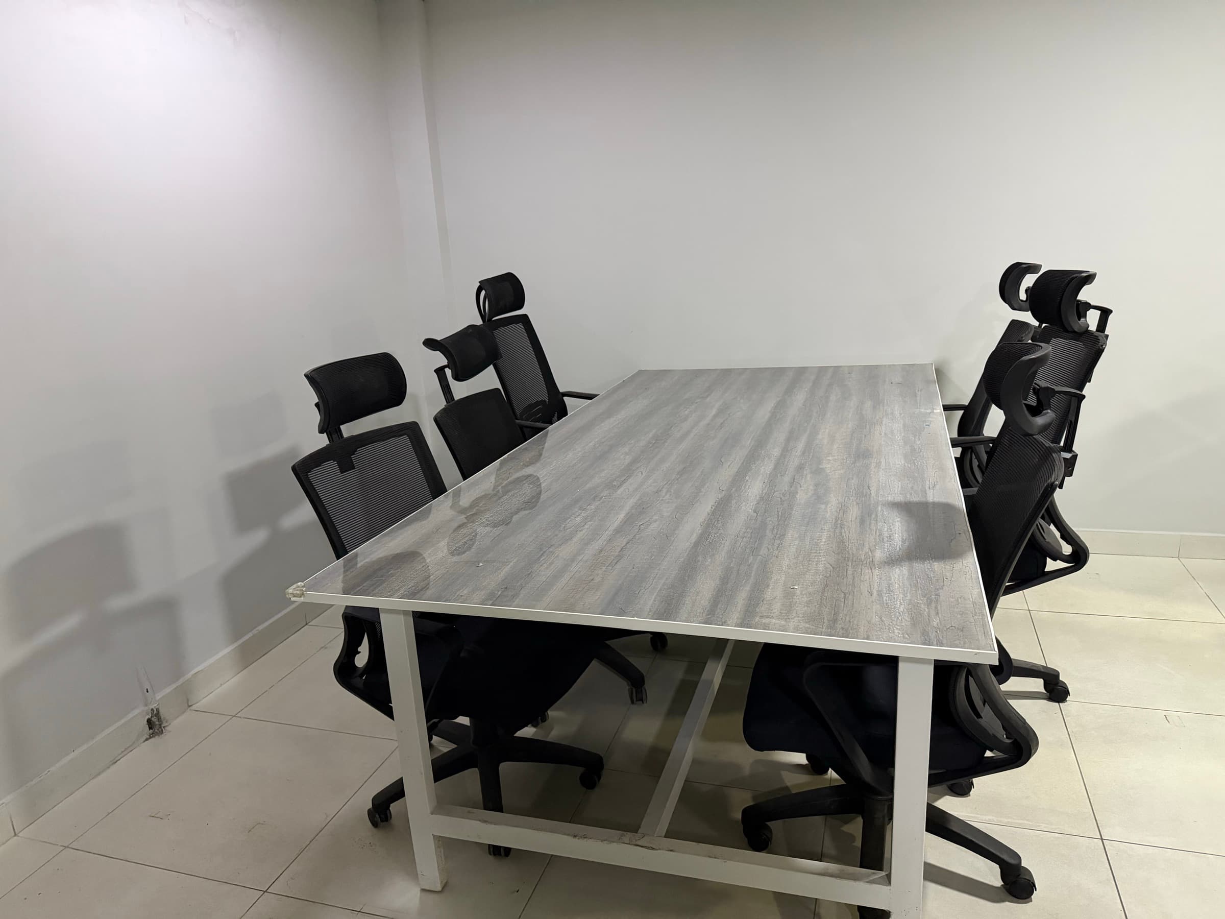 A private room inside the floor, with a single table and six office chairs around it.